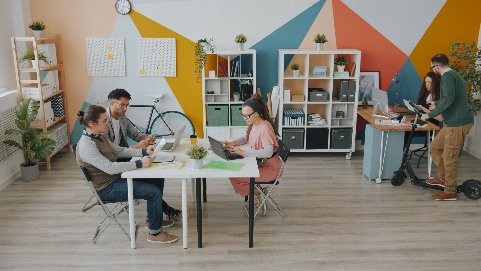 Diverse group of adults working in a creative, modern office space, fostering collaboration and innovation.